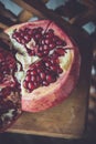 Juicy pomegranate fruit on a wooden suport.