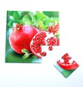 Juicy pomegranate and its half with leaves photo on puzzle boards Royalty Free Stock Photo
