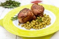 Juicy pork medallions wrapped in bacon, serve with green peas and a sprig of rosemary Royalty Free Stock Photo