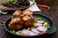 Juicy pork medallions wrapped in bacon, serve on the iron pan on the dark wooden dackground Royalty Free Stock Photo