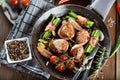 Juicy pork medallions wrapped in bacon, serve on the iron pan on the dark wooden dackground. Close up. Royalty Free Stock Photo