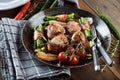 Juicy pork medallions wrapped in bacon, serve on the iron pan on the dark wooden dackground. Close up. Royalty Free Stock Photo