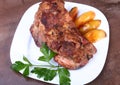 Juicy pork neck chops are grilled with potatoes on a white plate. Royalty Free Stock Photo