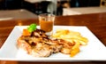 Juicy porkchop on white plate Royalty Free Stock Photo