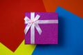 Juicy purple gift box stands on a colorful background