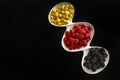 Raspberry, blackberries and dogeberry in white plate on black background Royalty Free Stock Photo