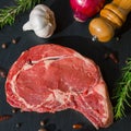 Juicy raw meat, beef entrecote on black background, top view, close up.