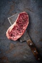 Juicy Raw new York beef steak on a wooden meat axe on a stone table