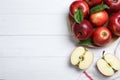 Juicy red apples on white table, flat lay. Space for text