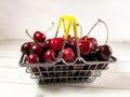 Juicy red cherries in a small supermarket basket on a background of wooden boards Royalty Free Stock Photo