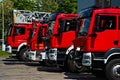 Juicy red fire trucks in front of the fire station.