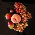 Juicy red ripe pears, plums, peach and grapes fruits on black background Royalty Free Stock Photo