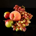 Juicy red ripe pears, plums, peach and grapes fruits on black background Royalty Free Stock Photo