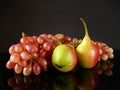 Juicy red ripe pears, plums, peach and grapes fruits on black background Royalty Free Stock Photo