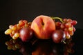Juicy red ripe pears, plums, peach and grapes fruits on black background Royalty Free Stock Photo