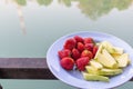 Juicy red strawberries are paired with crunchy, sweet green raw mangoes on a plate for customers to choose after last meal, and
