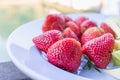 Juicy red strawberries are paired with crunchy, sweet green raw mangoes on a plate for customers to choose after last meal, and Royalty Free Stock Photo