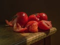 Juicy red tomatoes, on a wooden table, with a dark background, soft light. Imitation of a Dutch kitchen still life. Mono food Royalty Free Stock Photo