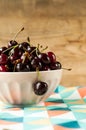 Juicy  ripe  beautiful sweet cherry on a ceramic black plate on a wooden background Royalty Free Stock Photo