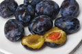 Juicy ripe black and blue plums on a plate Royalty Free Stock Photo