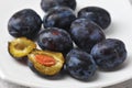 Juicy ripe black and blue plums on a plate Royalty Free Stock Photo