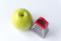 Juicy ripe green apple and a small grater, isolated on a white background Royalty Free Stock Photo