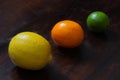 Juicy ripe lemon, citrus meyeri and lime on wooden background. Citrus fruit on a dark table. Beautiful fresh fruit. Food Royalty Free Stock Photo