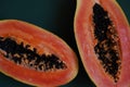 juicy ripe papaya halves on green background, tropical fruit close-up Royalty Free Stock Photo