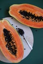 juicy ripe papaya halves on green background, tropical fruit close-up