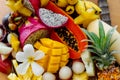 Juicy ripe tropical Thai fruits on a wooden dish.