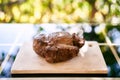 Juicy roast beef lies on a wooden cutting board on a table on the balcony Royalty Free Stock Photo