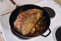 Juicy roast beef stewed in a pan on the stove