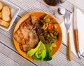 Juicy roast pork on a plate with stewed vegetables
