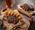 Juicy steak on the grill With rosemary, garlic, chili and corn on the grill and bread on the wooden board and BBQ spare Royalty Free Stock Photo