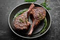 Juicy steak grilled on the bone with spices and herbs. On a black stone background. Top view. Free copy space Royalty Free Stock Photo