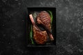Juicy steak grilled on the bone with spices and herbs. On a black stone background. Top view. Free copy space Royalty Free Stock Photo