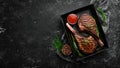 Juicy steak grilled on the bone with spices and herbs. On a black stone background. Top view. Free copy space Royalty Free Stock Photo