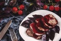 Juicy steak well done roast pork with red sauce and Basil leaves on a white plate over a black marble table Royalty Free Stock Photo