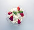 Juicy strawberries with cream in a transparent glass bowl on a white background Royalty Free Stock Photo