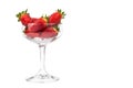 Juicy strawberries in a transparent cocktail glass with white ba