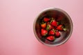 Juicy strawberry in metal bowl on pink background. View from the top. Royalty Free Stock Photo