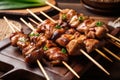 Juicy and succulent yakitori skewers with a sticky glaze, garnished with green onions and served on a rustic wooden platter