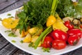 Juicy, summer vegetable salad cutting from fresh vegetables and greens in a beautiful serving on a wooden table Royalty Free Stock Photo