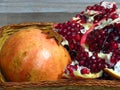 Juicy sweet ripe yellow red summer autumn pomegranate fruit in a basket on bleached oak wood background. Pomegranate seeds. Royalty Free Stock Photo