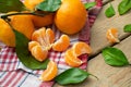 Juicy tangerines mandarin fruits on wooden background. Citrus fruits on a napkin