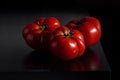 Juicy tomatoes on a wooden dark background
