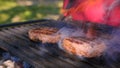 Juicy two cutlets beef burgers are fried over high heat on bbq grill with sparks of ash and flame. Cooking hamburger Royalty Free Stock Photo