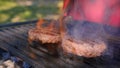 Juicy two cutlets beef burgers are fried over high heat on bbq grill with sparks of ash and flame. Cooking hamburger Royalty Free Stock Photo