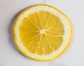 Juicy vibrant yellow orange slice closeup on white backing