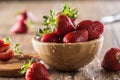 Juicy washed strawberries in wooden bowl on kitchen table Royalty Free Stock Photo